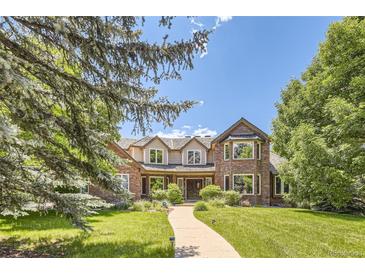 Charming brick and siding home featuring a landscaped front yard, mature trees, and inviting curb appeal at 4681 S Columbine Ct, Cherry Hills Village, CO 80113