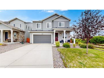 Charming two-story home with a well-manicured lawn, grey siding, and a welcoming front porch at 4585 High Mesa Cir, Castle Rock, CO 80108