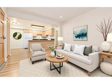 Bright living room featuring an open floor plan, modern furnishings, and hardwood floors at 5995 W Hampden Ave # 3E, Denver, CO 80227