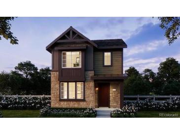 Charming two-story home with stone accents and a beautifully landscaped front yard at 7249 Goldbloom Ln, Littleton, CO 80125