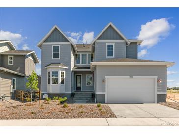 Charming two-story home featuring gray siding, a two-car garage, and a well-manicured front yard at 890 Coal Bank Trl, Castle Rock, CO 80104