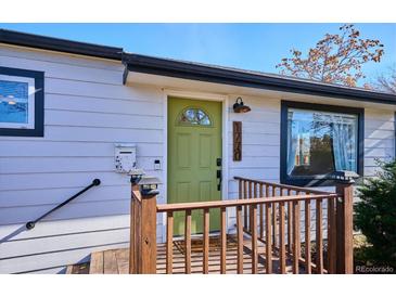 Charming single-Gathering home featuring a porch with wood railing and an attractive green front door at 1770 S Yuma St, Denver, CO 80223