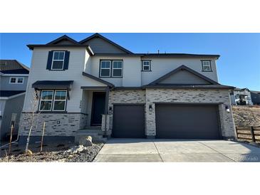 Inviting two-story home with a two-car garage and stone accents, creating a charming and modern curb appeal at 3340 Backdrop Ct, Castle Rock, CO 80108