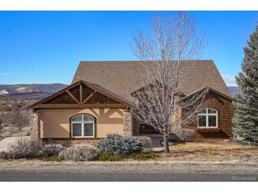 Charming home showcasing a mix of siding, stone accents, and a beautiful front yard with mountain views at 3441 Medallion Rd, Castle Rock, CO 80104