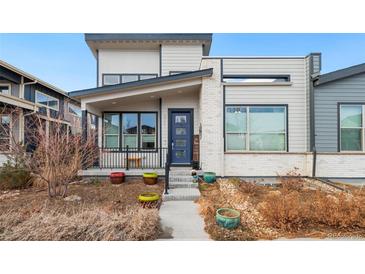 Modern two-story home with a blue door and landscaped front yard at 5731 Boston Ct, Denver, CO 80238