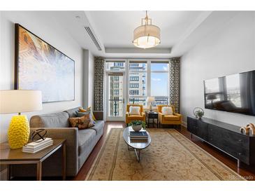 Bright living room featuring hardwood floors, a comfortable sofa, and large windows with city views at 5455 Landmark Pl # 903, Greenwood Village, CO 80111