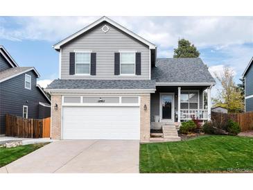 Charming two-story home with gray siding, brick accents, a well-manicured lawn, and an attached two-car garage at 18997 E Crestridge Cir, Aurora, CO 80015