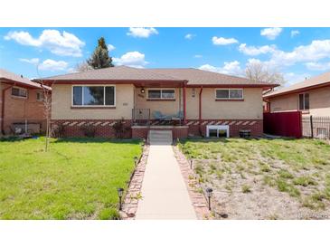 Charming single-story home with brick accents, covered porch and walkway with beautiful landscaping at 3559 Hudson St, Denver, CO 80207