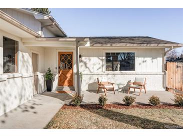 Inviting front porch with diamond-paneled wood door and chairs for relaxing at 360 S Hoyt St, Lakewood, CO 80226