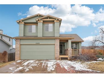 Charming two-story home with an attached garage, brick accents and freshly painted in a neutral color palette at 12690 W Brandt Dr, Littleton, CO 80127