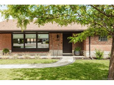 Charming brick home featuring a professionally landscaped yard and inviting front entrance at 2060 Kline St, Lakewood, CO 80215