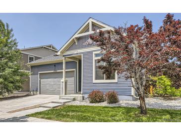 A cozy home exterior showing the garage, lawn, and well-placed landscaping at 12993 E 108Th Ave, Commerce City, CO 80022