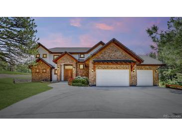Stunning stone and stucco home with a three-car garage and lush landscaping at 11790 Huckleberry Dr, Franktown, CO 80116