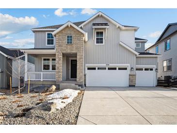 Charming two-story home with stone accents, a welcoming porch, and three-car garage at 3350 Backdrop Ct, Castle Rock, CO 80108