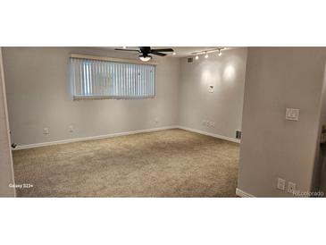 This bedroom features neutral walls, carpet flooring, ceiling fan and horizontal blinds at 12170 Huron St # 106, Denver, CO 80234