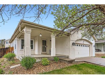 Charming home with a covered front porch, two car garage and low maintenance landscaping in front at 12507 Dexter Way, Thornton, CO 80241