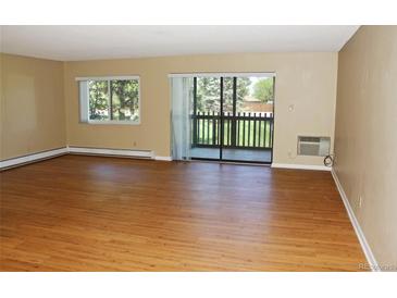 Bright living room featuring wood floors, large window, and sliding glass door to a private balcony at 14390 E Marina Dr # 204, Aurora, CO 80014