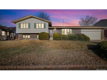 Charming two-story home boasts green shutters, brick accents, and mature landscaping in a tranquil neighborhood at 10636 Ura Ln, Northglenn, CO 80234