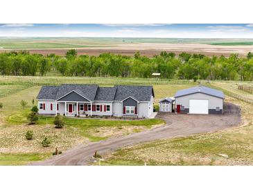 Charming ranch-style house with red shutters and a spacious workshop, nestled in a serene country setting at 196 W 8Th Ave, Byers, CO 80103