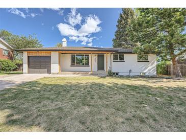 Charming single story home featuring a well-kept lawn, a covered porch, and attached garage at 8463 W Arizona Dr, Lakewood, CO 80232
