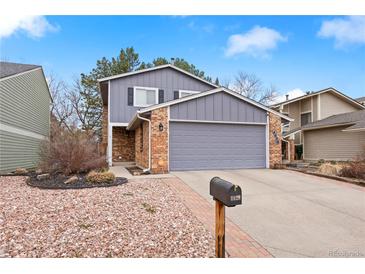 Charming two-story home with a brick and gray exterior, an attached garage, and a well-maintained front yard at 4028 S Atchison Way, Aurora, CO 80014