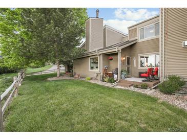 Charming home exterior with a well-maintained lawn, deck, and neutral siding at 6948 Buckskin Dr, Littleton, CO 80125