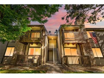 Charming condo building featuring balconies with stone accents and mountain views at sunset at 1758 S Pitkin Cir # A, Aurora, CO 80017
