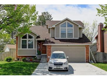 Charming two-story home boasts a well-maintained yard, a driveway with a white car, and beautiful architectural features at 8555 Angela Ln, Parker, CO 80134
