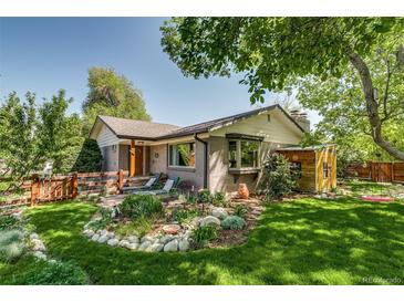 Charming home with a well-maintained front yard, lush lawn, and a cozy seating area at 3010 Zinnia Ct, Golden, CO 80401