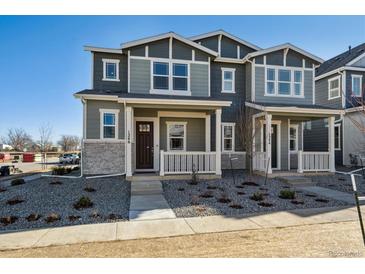 Charming two-story home with stone accents, landscaped yard, and inviting front porch at 1246 Penner Dr, Erie, CO 80026