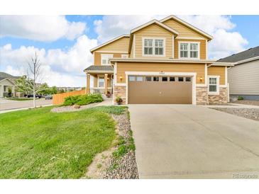 Inviting two-story home with a well-manicured lawn, a large garage, and beautiful stone accents at 3762 White Rose Loop, Castle Rock, CO 80108