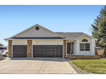 Charming home featuring a three-car garage, brick accents, and a well-manicured lawn at 2066 E 129Th Ave, Thornton, CO 80241
