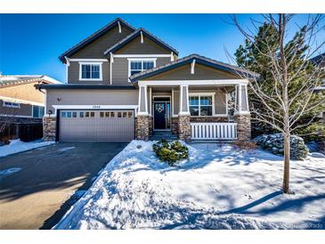 Two-story house with a gray exterior, snowy front yard, and a two-car garage at 5808 S Duquesne Ct, Aurora, CO 80016