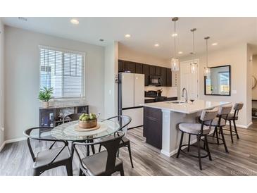 Modern kitchen with island, stainless steel appliances, and white quartz countertops at 5921 Wheatberry Dr, Brighton, CO 80601