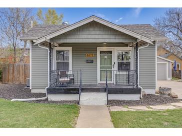 Charming home featuring a cozy front porch with a sitting area, and a well-maintained yard at 4478 S Acoma St, Englewood, CO 80110
