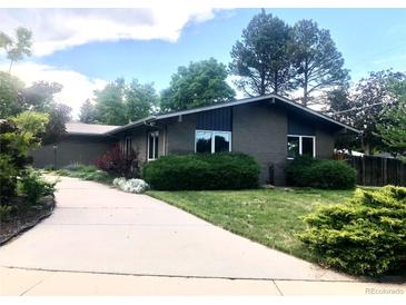 Charming one-story home with a brick exterior, mature trees, and a long driveway at 3001 S Vine St, Denver, CO 80210
