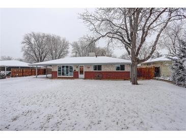 Charming brick home featuring a covered carport and a snow-covered front yard at 460 Lansing St, Aurora, CO 80010