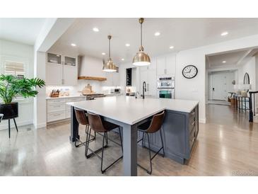 Bright, open kitchen featuring a large island with seating and modern pendant lighting at 493 Pine Flower Ct, Highlands Ranch, CO 80126