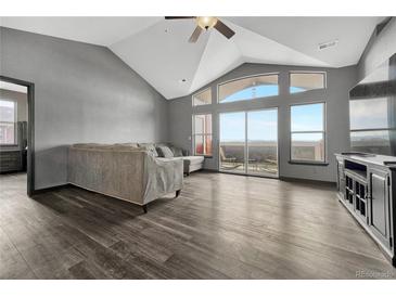 Bright living room with vaulted ceilings, large windows, and access to a private balcony overlooking the mountains at 14333 E 1St Dr # 307, Aurora, CO 80011