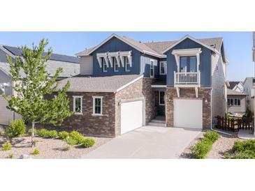 Beautiful two-story home with stone accents, blue siding, and a well-manicured front yard at 18875 W 93Rd Ave, Arvada, CO 80007