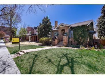 Charming brick home featuring a well-manicured lawn and classic architectural details at 1545 N Harrison St, Denver, CO 80206