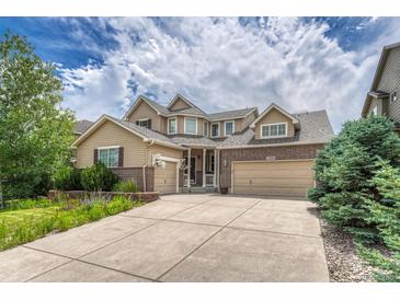 Attractive two-story home featuring a three-car garage, well-maintained lawn, and beautiful landscaping at 15886 E Stargazer Ln, Parker, CO 80134