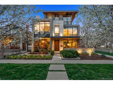 Contemporary home with large windows, stone accents, and landscaped front yard at dusk at 2539 E 5Th Ave, Denver, CO 80206