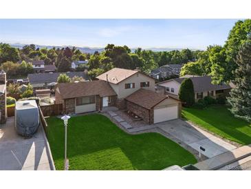 Charming home boasts a lush lawn, mature trees, and inviting curb appeal in a desirable neighborhood at 7351 S Marion St, Centennial, CO 80122
