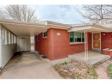 Charming single-story red brick home with a covered car port and well-maintained yard at 2885 S Gilpin St, Denver, CO 80210