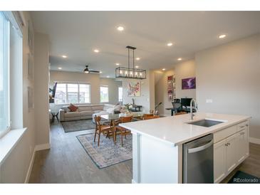 Open concept living area features a modern kitchen, dining space, and comfortable living room at 10018 E 62Nd Ave, Denver, CO 80238