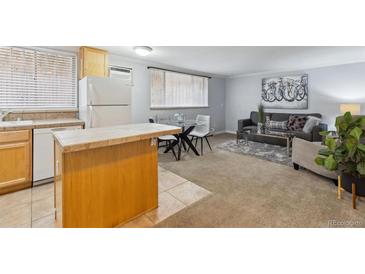 Open-concept living room and kitchen area with hardwood flooring and contemporary furnishings at 1260 N Humboldt St # 1, Denver, CO 80218