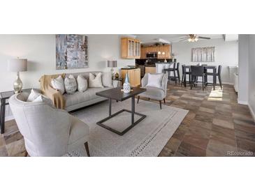 Living room with gray sofa, decorative pillows, area rug, and an open floor plan to the kitchen at 909 N Logan St # 11A, Denver, CO 80203