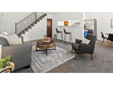 Cozy living space with bar stool seating, soft rug, and view into kitchen area at 7700 W Glasgow Place # 15A, Littleton, CO 80128