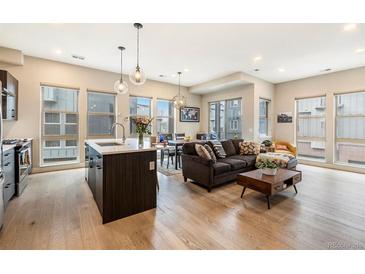 Bright open-concept living room featuring hardwood floors and large windows at 2695 W Grand Ave, Littleton, CO 80123